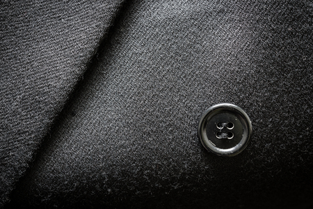 Closeup of a suit texture with button on a business coat