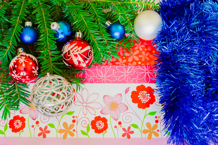 Christmas background with pine tree branches, decorations and baubles on floral boardの写真素材