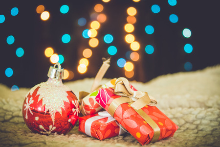 Christmas background with pine tree branches, presents and pine cones with blue and yellow lights. Colorful baubles, blue holiday decorationsの写真素材