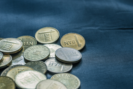Mixed stack of european coins on a blue silk background