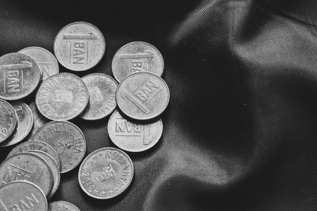 Mixed stack of european coins on silk background. Black and white picture