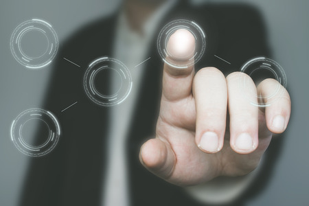 Businessman in suit points on something on upper part of the screen