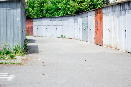 old metal comunist vandalized garages surrounded by treesの写真素材