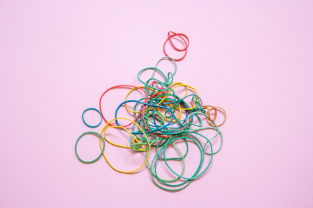 A multicoloured background showing a heap of colourful elastic rubber bandsの写真素材