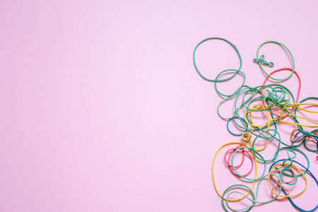 A multicoloured background showing a heap of colourful elastic rubber bandsの写真素材