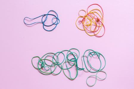 A multicoloured background showing a heap of colourful elastic rubber bandsの写真素材