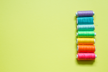 Color cotton yarns on rolls for sewing with lime green backgroundの写真素材