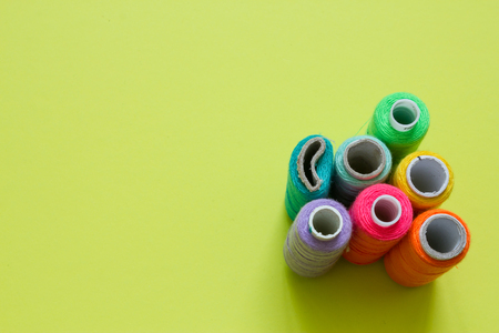 Color cotton yarns on rolls for sewing with lime green backgroundの写真素材