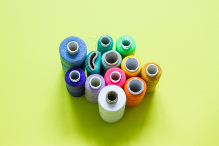 Color cotton yarns on rolls for sewing with lime green backgroundの写真素材
