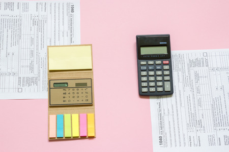 US tax form 1040 with calculator. tax form. law document usa. pink background. mathematics business concept.の写真素材