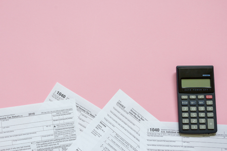 US tax form 1040 with calculator. tax form. law document usa. pink background. mathematics business concept.の写真素材