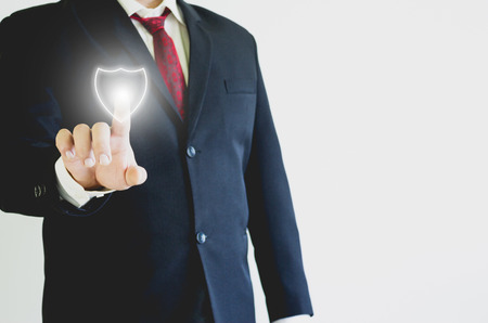 Businessman pressing shield icon in the airの写真素材