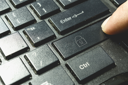 Locked padlock icon on keyboard. Finger pressing button. Cyber security concept.の写真素材