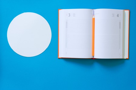 Top view blue desk table. Office tools on colored background. Flat lay of workspaceの写真素材