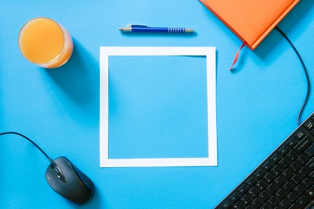 Top view blue desk table. Office tools on colored background. Flat lay of workspaceの写真素材