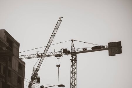 Black and white shot of a lifting crane on a construction siteの写真素材