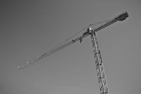Black and white shot of a lifting crane on a construction siteの写真素材