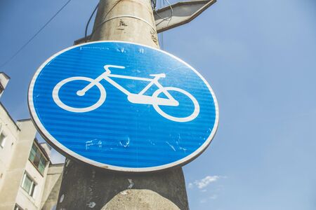 Bicycle blue round road sign on a street pillar in a neighbourhoodの写真素材