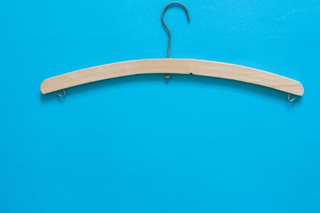 Simple wood hanger on blue backgrund with copy spaceの写真素材