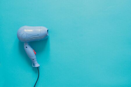 Blue hair dryer for girls on background with copy spaceの写真素材
