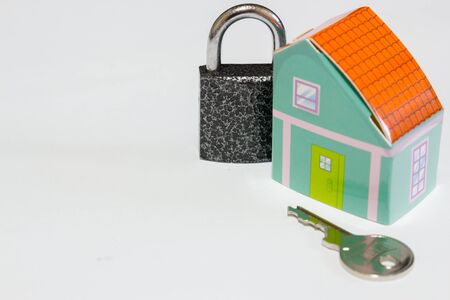 Home security concept image made of a key, a house and a locked padlock on white backgroundの写真素材