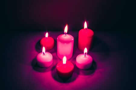 Abstract background of a group of candles emitting purple light in the darkの写真素材