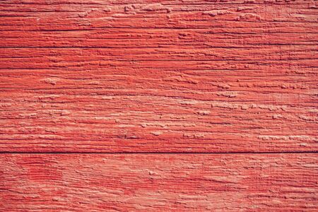 Backdrop of a closeup red painted planks with natural lightの写真素材