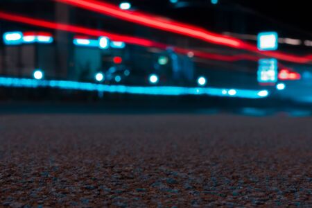 Close up to a street texture with fast cars trail lights at nightの写真素材