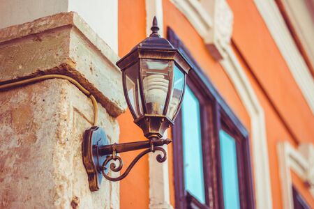 Beautiful antique lantern design with light bulb in it hanged on wallの写真素材