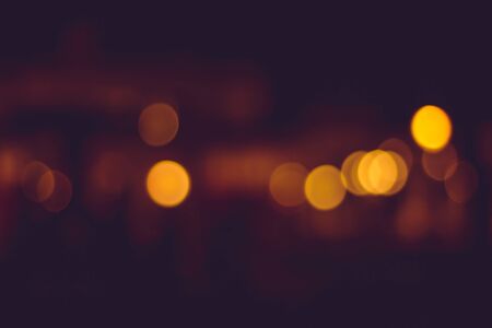 Blurry distant city lights at night. Calm yellow blurry traffic lights in the distanceの写真素材