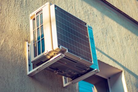 Low angle view of an old air conditioner system. Big air conditioner placed on a wall outsideの写真素材