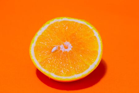Top view of a half sliced orange with a small orange bean in the middle.の写真素材