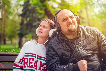 Boy wearing a black leather jacket and girl with a white blouse enjoying music at their big...