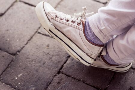 Sport shoes closeup with a gray pavement in the background during day time â€“ Up close photo...