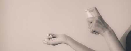 Young woman spraying perfume over her hand on a white background â Girl expressing elegance through simplicity â Concept image for testing scents and wedding preparationの写真素材