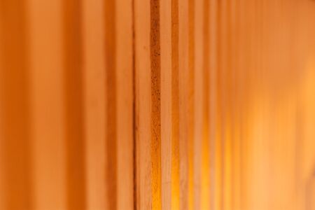 Closeup of a yellow textured wooden fence â Rough surface of weathered decorative planks â Wall made from solid timber for home protection and securityの写真素材