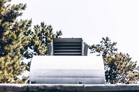 Big metallic rectangle air vent sitting on a building rooftop â Exterior ventilation system used for temperature adjustmentの写真素材