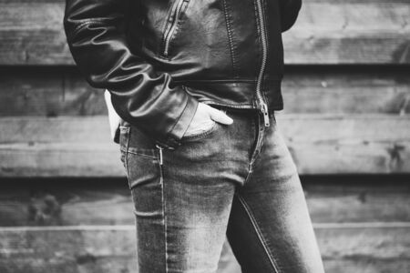 Woman wearing tight jeans and a leather jacket holding her hand in the pocket â Lady in a stylish and fashionable outfit during day time at countrysideの写真素材