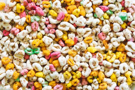 Bright color crunchy cereals with delicious fruit flavor â Background of heathy and nutritious breakfast full of vitamins and source of fiberの写真素材