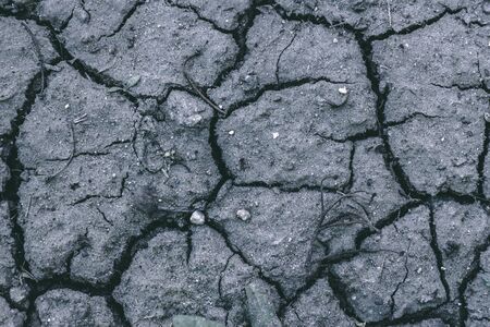 Close-up shot of heavily cracked land with a rough surface â€“ Destroyed and broken grey road...