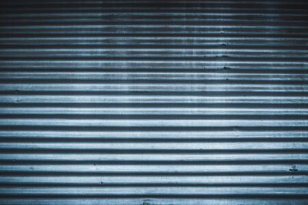 Curved metallic door with horizontal parallel stripes â Garage entrance made from hard steel with a rough surface â industry background with detailed rusty textureの写真素材