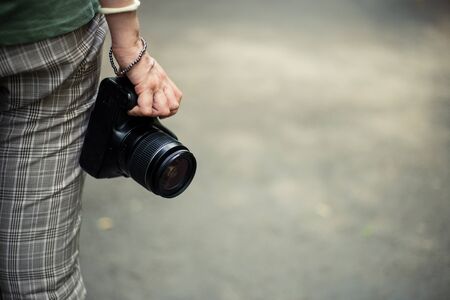 Small video camera held by young woman hand with copy space â Casually dressed girl with modern recording equipment â Professional device for photo shootingの写真素材