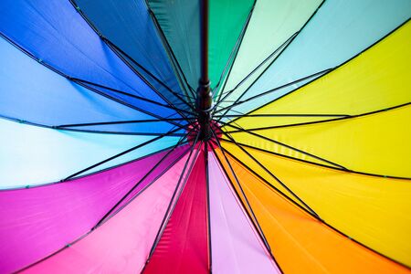 Rainbow colored umbrella with black metal opening system â Abstract multicolored background of nylon material of waterproof sunshadeの写真素材
