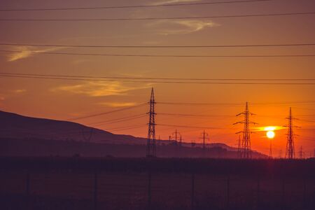 Silhouette of electric pillars high voltage technology in the sunset.の写真素材