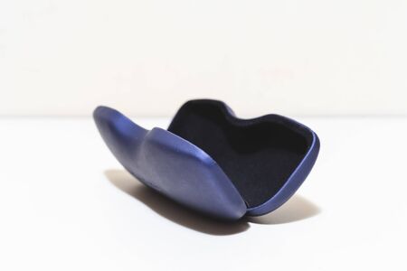 Open glasses case placed on white background with copy space â€“ Blue plastic package for...