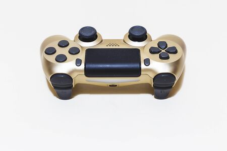 Golden gamepad with black buttons and joysticks on white background with copy space â€“ Gaming...