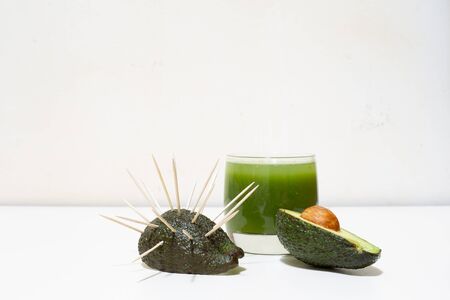 Funny avocado background with some toothpicks in half of the fruit â€“ Humoristic concept image...