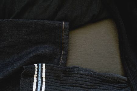 Pile of dirty laundry on black background - Socks, jeans and shirt crumpled on the floorの写真素材
