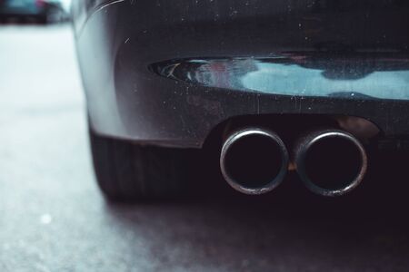 Exhaust pipe evacuation holes from the rear of a car - Concept image of vehicle emissions in trafficの写真素材