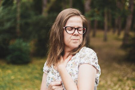Alone woman scared due to having panic attack caused by fear outdoors - Casually dressed girl wearing eyeglasses having mental disorders and depressionの写真素材